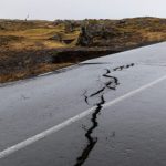 Cracks emerge on a road due to volcanic activity near a golf course, in Grindavik