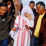 A Palestinian couple walks on their wedding day in the tent camp in Rafah